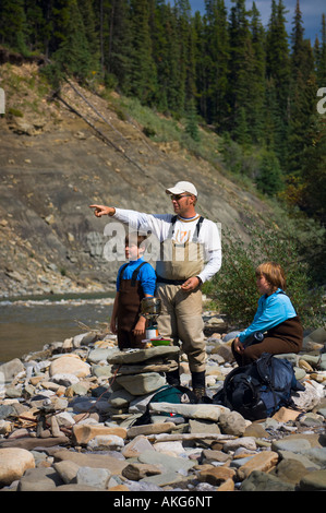 Vater und Söhne am Fluss-Ufer Stockfoto