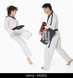 Weibliche Karate-Lehrer unterrichten Kampfkünste zu einem jungen Mann Stockfoto