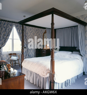 Blau gestreift Vorhänge und Wertigkeit auf Himmelbett im Schlafzimmer mit blau weiß floral Gardinen passende Tapete Stockfoto