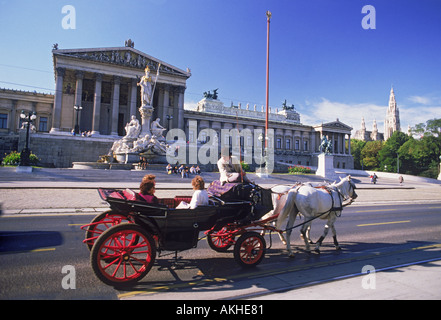 Wagen mit Touristen auf der Ringstraße, vorbei an Parlament und Athena-Statue in Wien Stockfoto