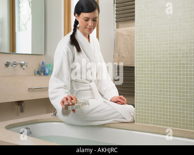 Junge Frau, die Vorbereitung einer Badewanne Stockfoto