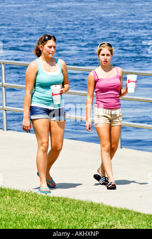 Zwei weibliche High-School-Freunde plaudern über Jungs, wie sie entlang des Flussufers in Port Huron Michigan MI Fuß Stockfoto