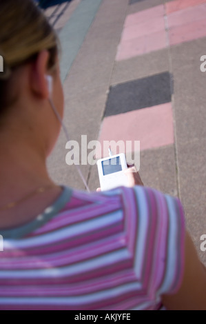 Teenager-Mädchen einen Ipod anhören, während zu Fuß Stockfoto