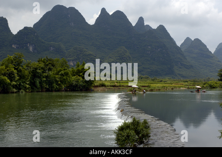 China Guangxi Yangshuo zwei Bambus Flöße absteigend Yulong Fluss bereit zum Pass über einen Deich Stockfoto