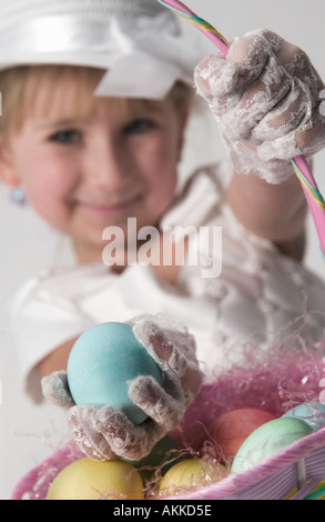 Mädchen-Kommissionierung-Eiern aus Korb Stockfoto