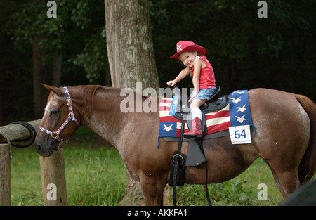 Junges Mädchen auf Appaloosa-Stute wird niedlich zur Pferde-show Stockfoto