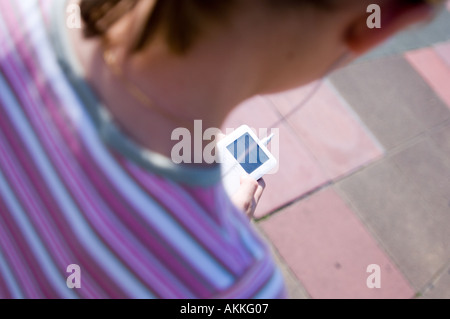 Teenager-Mädchen einen Ipod anhören, während zu Fuß Stockfoto