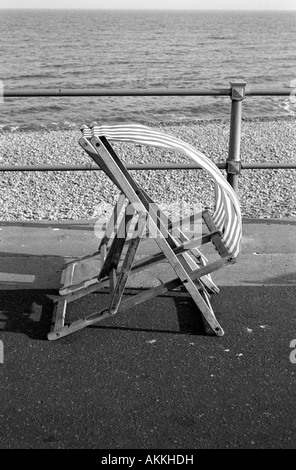 Zwei Liegestühle auf Sidmouth wogenden Meer, Devon, England, in den Wind in schwarz und weiß Stockfoto