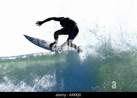 Surfer, die eine Wendung aus Spitze von brechende Welle schnitzen Stockfoto