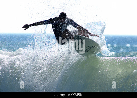 Surfer, die fast in der Luft auf der Oberseite Welle schnitzen Stockfoto