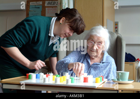 Ältere Frau Patienten spielt Solitaire mit einer Krankenschwester im Krankenhaus Ward England UK Stockfoto