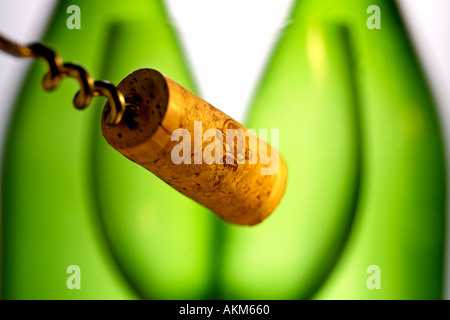 KORKEN AM ENDE DER KORKENZIEHER ZWEI GRÜNE FLASCHEN WEIN UND WEIN GLAS IM HINTERGRUND Stockfoto
