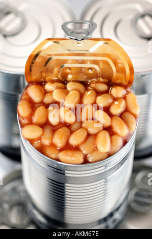 ZINN KONSERVENDOSEN GESTAPELT MIT EINEM CANOPEN GEFÜLLT MIT GEBACKENEN BOHNEN IN TOMATENSAUCE Stockfoto