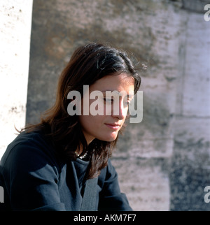Eine nachdenkliche junge Italienerin blickte auf den Boden neben einer Säule am Kolosseum Rom Italien KATHY DEWITT sitzt Stockfoto
