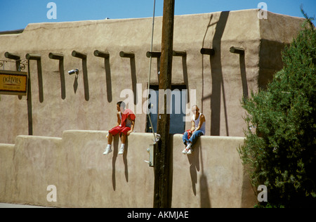 Zwei junge Männer Touristen entspannen Sie sich auf eine Adobe-Wand der Ogelvies Taos Grillbar Innenstadt von Taos New Mexico USA Stockfoto