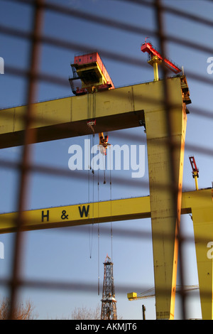 Samson und Goliath Krane in Belfast Werft durch geschlossene Werkstore, Belfast, Nordirland angesehen Stockfoto
