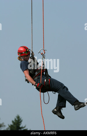 Fire Fighter Special Services Team weibliches Mitglied während einer Antenne Demonstration von Seilen hängen. Dort hängen! Stockfoto