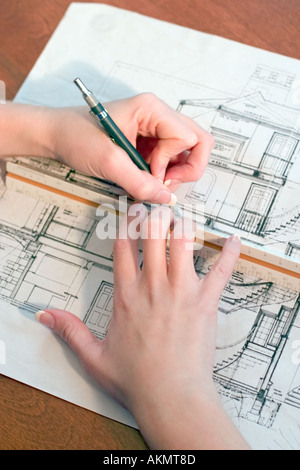 Hände eines weiblichen, Linkshänder Architekten arbeiten auf einer Zeichnung von Hausplänen. Stockfoto
