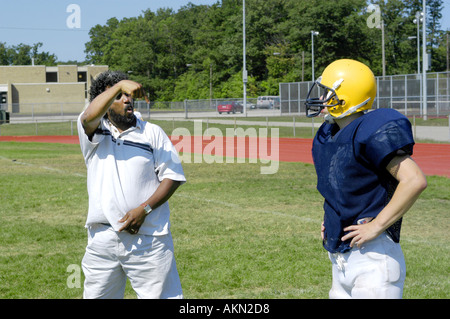 High School Football Aktion Port Huron Michigan Deaf JV Fußballspieler liest Gebärdensprache durch schwarze Hilfe während des Trainings gegeben Stockfoto