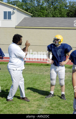 High School Football Aktion Port Huron Michigan Deaf JV Fußballspieler liest Gebärdensprache durch schwarze Hilfe während des Trainings gegeben Stockfoto