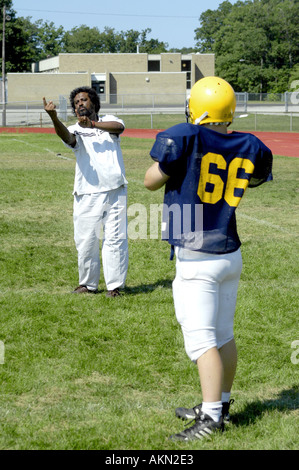 High School Football Aktion Port Huron Michigan Deaf JV Fußballspieler liest Gebärdensprache durch schwarze Hilfe während des Trainings gegeben Stockfoto