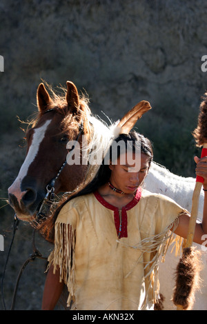 Ein Native American Indian-junge trägt eine Feder stand neben einem Pferd hält einen Speer mit Buffalo ausblenden drauf Stockfoto