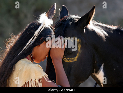Ein Native American Indian-junge trägt eine Feder, die gemeinsam einen besonderen Moment mit seinem Pferd Stockfoto