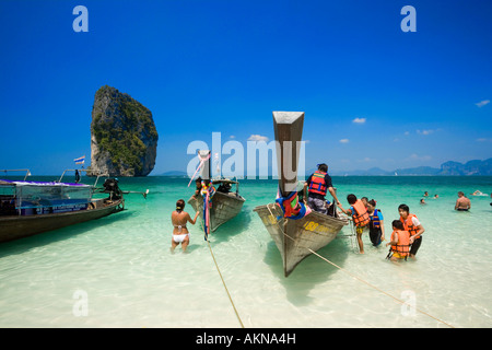 Boote am Strand Touristen mit Schwimmwesten stehen im Wasser Ko Poda Laem Phra Nang Railay Krabi Thailand verankert Stockfoto