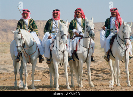 Beduinen Männer reiten Pferde in der Wüste in Saudi Arabien Stockfoto