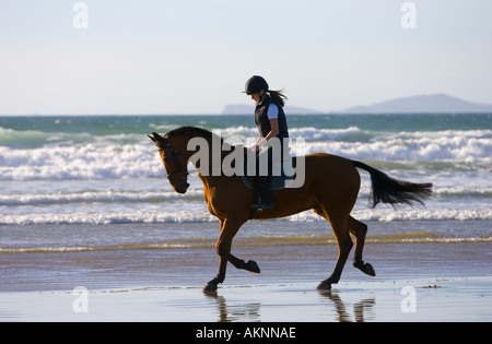 Junge Frau reitet auf einem Pferd Bucht auf breiten Haven Beach Pembrokeshire Wales Großbritannien Stockfoto