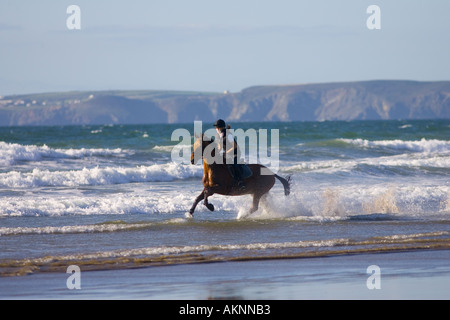 Junge Frau reitet auf einem Pferd Bucht auf breiten Haven Beach Pembrokeshire Wales Großbritannien Stockfoto