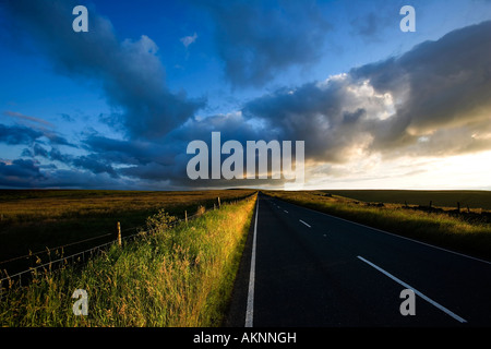 Lange gerade Straße, die durch offenes Land führt Stockfoto