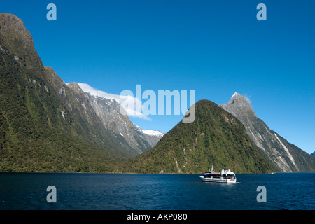 Eine Kreuzfahrt-Schiff am Milford Sound mit Mitre Peak hinter, Fiordland-Nationalpark, Südinsel, Neuseeland Stockfoto