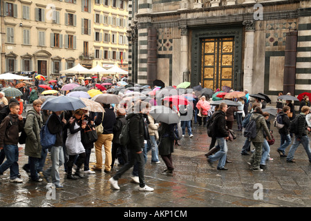 Touristen wandern im Regen, das Baptisterium, in der Nähe des Duomo, Florenz, Italien Stockfoto