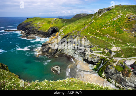 Tintagel Haven an der kornischen Küste von Tintagel Castle betrachtet. Ein Wasserfall gießt auf den Strand. Tintagel, Cornwall. Stockfoto