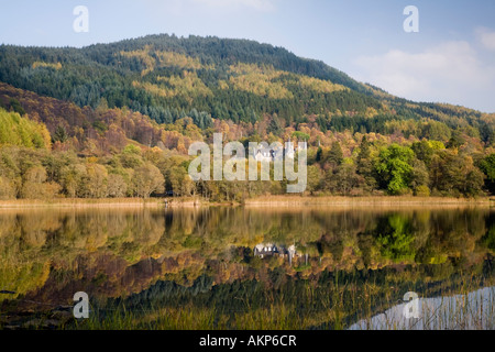 Herbstliche Aussicht auf Loch Achray zum ehemaligen Trossachs Hotel jetzt Tigh Mor Timeshare im Trossachs National Park Stockfoto