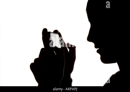 Eine Silhouette eines jungen Teenagers, der auf einer Sony PSP Handheld-Computerspielkonsole spielt. Bild von Jim Holden. Stockfoto