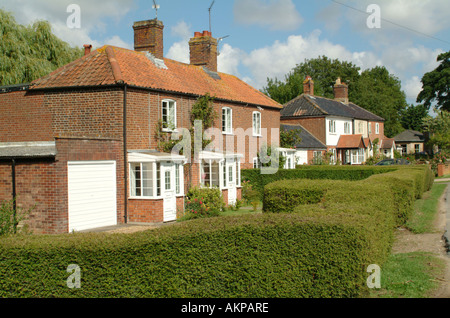 Reihe von Hütten neben Thurne Deich in das Dorf Thurne, Norfolk Broads, England, UK. Stockfoto