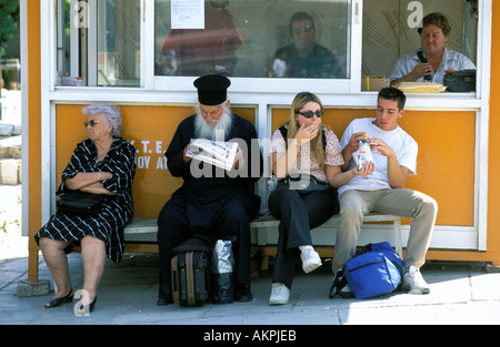 Athen, die Wartezeit auf den Bus mit orthodoxer Priester Stockfoto