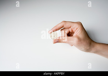 Eine Person, die eine Pfund-Münze Stockfoto