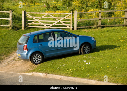 Blauer Volkswagen Fünftürer Fließheck-Polowagen, geparkt am Grasstreifen England UK Stockfoto