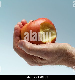 HERR MANN HAND HÄLT EINEN APFEL GEBISSEN PINK LADY Stockfoto