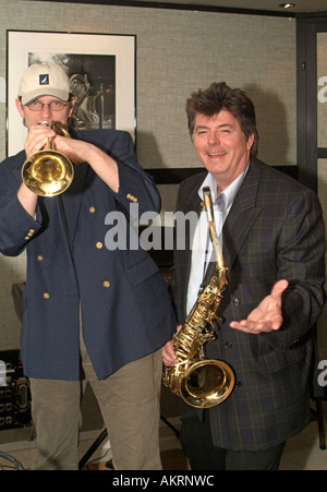 zwei Musiker mit Instrumenten Saxsophone und Trompete posieren und spielen vor einem Plakat Bild eines Jazzmusikers Stockfoto