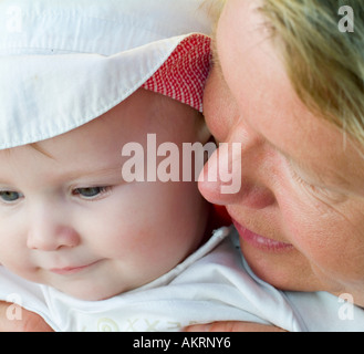 Großmutter und Enkel Porträt eines Babys von 8 Monaten mit Sonnenhut und eine Frau im Alter von etwa 45 bis 55 Jahren Stockfoto