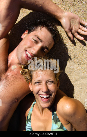 Lächelnd Brautpaar liegend im Sand am Strand von Maui Hawaii Stockfoto