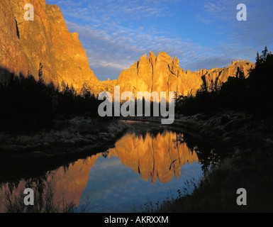 Ein Blick auf die goldenen Klippen von Smith Rock spiegelt sich in der Crooked River in der Morgendämmerung an einem Sommermorgen Stockfoto