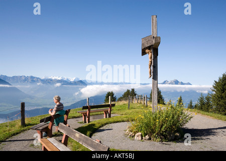 Frau ruht auf Bank vor einem Kruzifix Rigi Kulm 1797 m Kanton Schwyz Schweiz Stockfoto