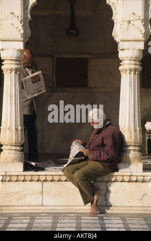 Hindu Mann liest im Karni Mata Tempel, Deshnok, in der Nähe von Bikaner, Rajasthan, Indien Stockfoto