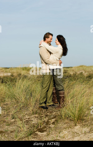 Paar steht in Dünen, umarmen Stockfoto