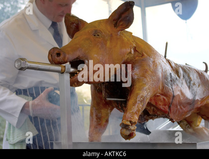 ein ganzes Schwein braten auf einem Grill Spieß mit Koch Stockfoto